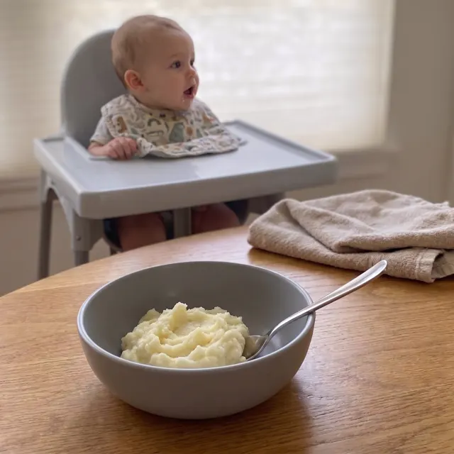 Bebé frente a un bol de puré de papa